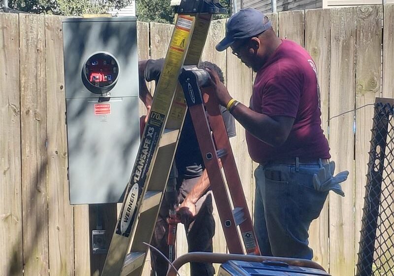 Palmetto Electric electricians installing a meter base and service equipment at a home